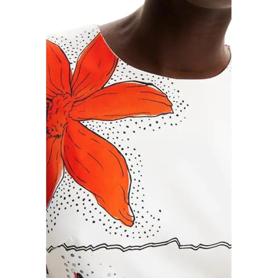 
                      
                        Desigual women dress model wearing a white top with a red flower
                      
                    
